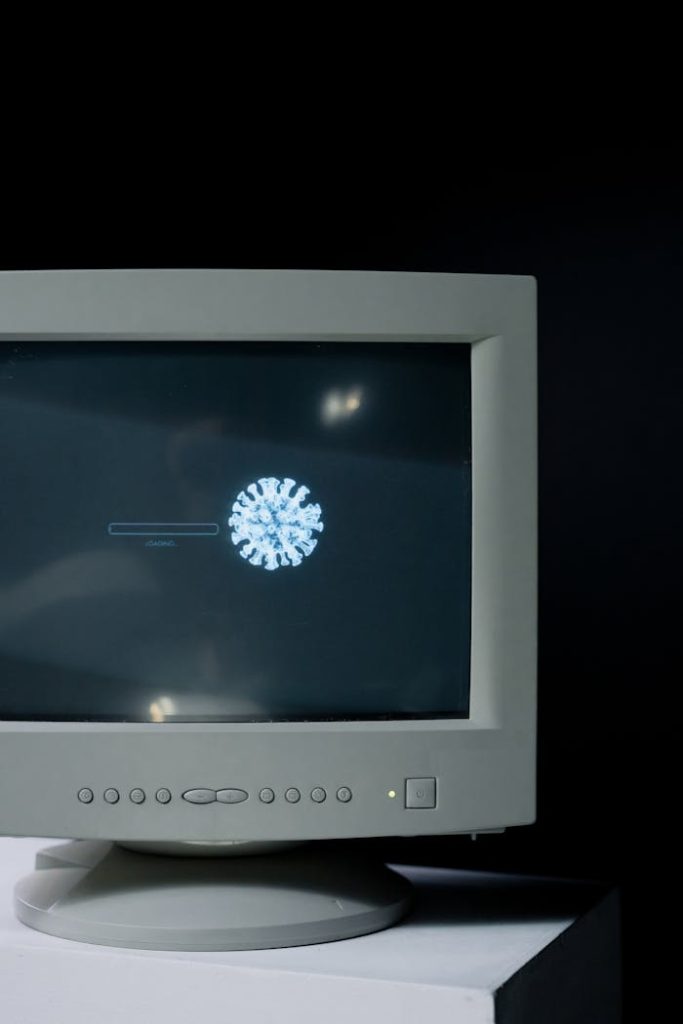 Retro computer monitor showing a virus symbol loading on the screen.